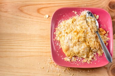 Pudra şekeri ile gevrek kurabiye. Lezzetli kırılgan tatlı kurabiye brushwood pembe bir tabak ve çay kaşığı üzerinde. Tabakta şeker ve pudra şekeri. Tatlı. Üst te. Kopya alanı. Yumuşak odaklama
