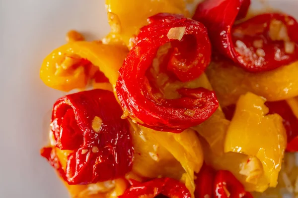 Beyaz bir tabakta pişmiş sarı kırmızı biber. Vejetaryen yemekleri. Yumuşak odak. Üst te. Closeup. 