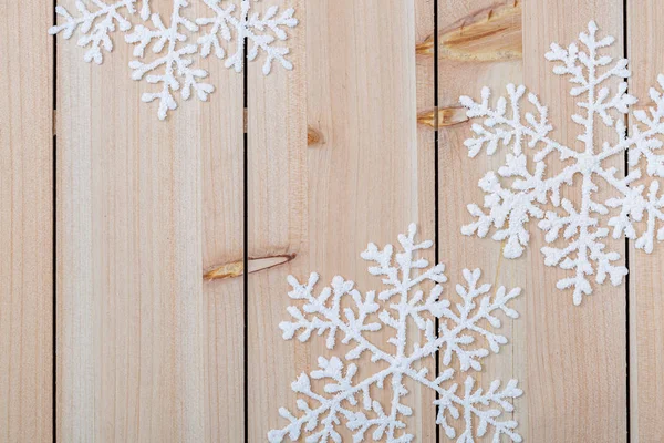Різдвяні прикраси фону і копіювати простір для тексту. Білі сніжинки на дерев'яному столі. З Різдвом Христовим і новим роком. — стокове фото