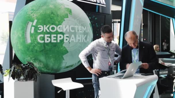 Dos empresarios discuten algo y mirar el portátil SPIEF Foro Económico Internacional de San Petersburgo 2019 Expoforum — Vídeo de stock
