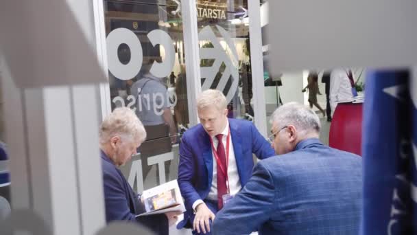 Bespreking van drie zakenlieden in een pak achter de glazen man gebaren Spief Sint-Petersburg internationaal economisch forum 2019 Expoforum — Stockvideo