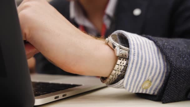 Χέρι ενός επιχειρηματία σε ένα κοστούμι πουκάμισο ρολόι επιτυχημένοι άνθρωποι το laptop εκτυπώσεις — Αρχείο Βίντεο