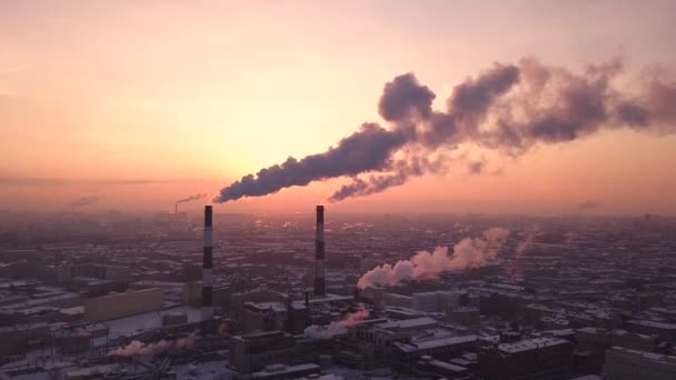 Dois tubos grandes em uma fábrica industrial fazem a fumaça branca no por do sol. Casas vistas ao fundo. Poluição ambiental em São Petersburgo, Rússia. Imagens aéreas — Vídeo de Stock