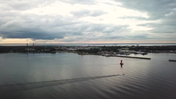 Singola barca a motore bianca galleggiante sul mare lungo la costa lasciando dietro di sé un sentiero bianco. Filmati aerei — Video Stock