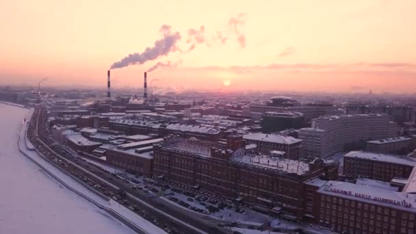 Dwie duże rury w fabryce przemysłowej sprawiają, że biały dym o zachodzie słońca. Domy widziane w tle. Zanieczyszczenie środowiska w Sankt Petersburgu, Rosja. Strzał z lotu ptaka — Wideo stockowe