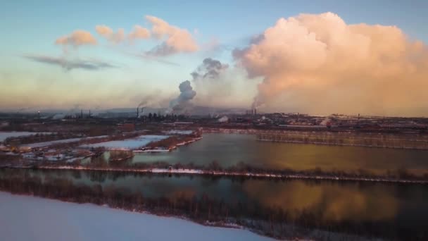 Strefa przemysłowa fabryki, dużo rur i dymu w pobliżu rzeki w zimie. Zanieczyszczenie środowiska w Rosji, Magnitogorsk. Ciemna ekologia. Zdjęcia lotnicze — Wideo stockowe