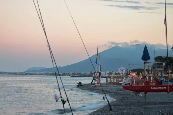 Ligúria, Itália: pescadores na praia ao pôr do sol quando os turistas retornam ao hotel — Fotografia de Stock