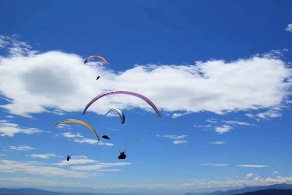 Grupa spadochroniarzy leci na spadochronie nad Alpami Włoskimi. — Zdjęcie stockowe