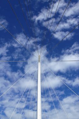 Arka planda gökyüzü olan bir köprünün iplerini fırlatmak.