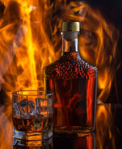 Still life with botle of whiskey on the background of fire