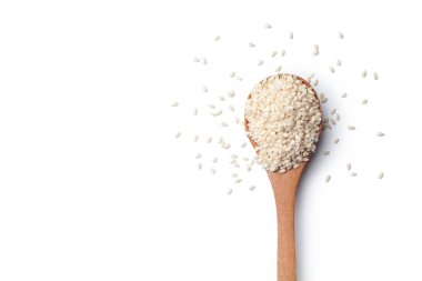 Bir tahta kaşık beyaz arka plan üzerinde beyaz susam tohumu