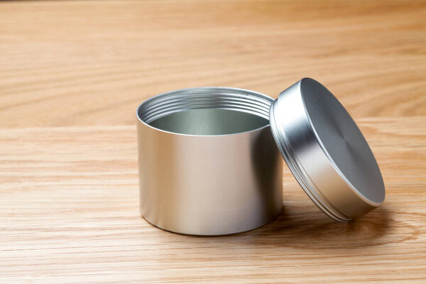 Metal can for tea packaging on wooden table