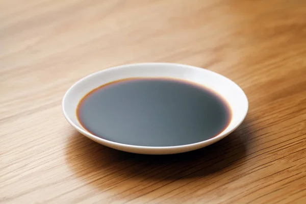 木製のテーブルに醤油の皿 — ストック写真