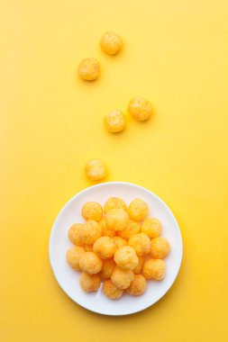 Sarı arka planda bir seramik çanak peynir topu. Üst görünüm.