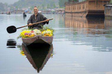 Srinagar, Jammu ve Keşmir, Hindistan - 16 Nisan 2019 : Keşmirli tüccarlar Dal Gölü'nde turistlere çiçek satmak için eski ahşap tekne kürek, Houseboat Srinagar seyahat hedef ünlü yer