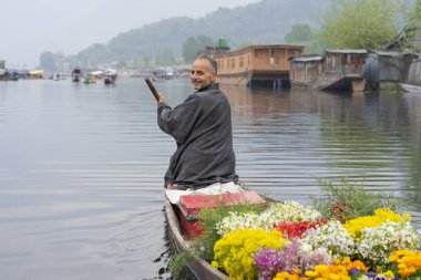 Srinagar, Jammu ve Keşmir, Hindistan - 15 Nisan 2019 : Dal Gölü'nde turistlere çiçek satmak için eski ahşap tekne kürek ile Keşmirli tüccarlar, Houseboat Srinagar seyahat hedef ünlü yerdir