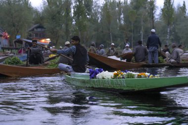 Srinagar, Jammu ve Keşmir - 16 Nisan 2019 : Keşmirli erkekler Hint sebze tüccarları Dal Gölü'nde yüzen pazarda günlük sabah erken saatlerde Srinagar önemli turistik