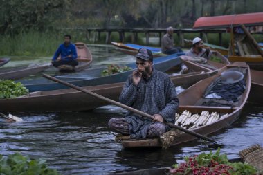 Srinagar, Jammu ve Keşmir - 16 Nisan 2019 : Keşmirli erkekler Hint sebze tüccarları Dal Gölü'nde yüzen pazarda günlük sabah erken saatlerde Srinagar önemli turistik