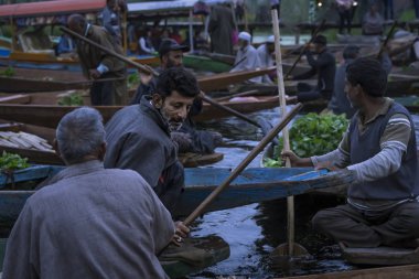 Srinagar, Jammu ve Keşmir - 16 Nisan 2019 : Keşmirli erkekler Hint sebze tüccarları Dal Gölü'nde yüzen pazarda günlük sabah erken saatlerde Srinagar önemli turistik