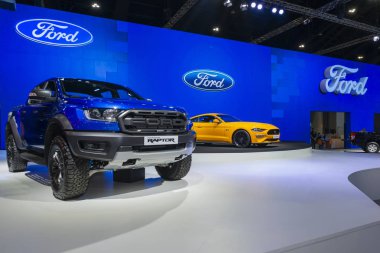 Bangkok, Thailand - November 28, 2018 : Ford Ranger Raptor with Mustang GT orange super sports car on display in 35th Motor Expo 2018 at Muang Thong Thani Exhibition & Convention Center Nonthaburi, Thailand  clipart