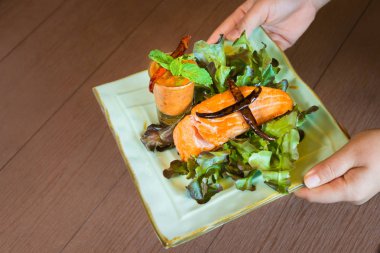 Sıcak ve baharatlı baharat sosu Tay tarzı ve ahşap masada sağlıklı için taze sebze lezzetli gıda ile Kavrulmuş somon biftek