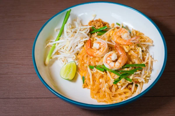 パッドタイの美味しい炒め物は人気の麺料理タイ伝統スタイル好きな有名なストリートフードは 木製のテーブルの上にタイの国民料理です — ストック写真