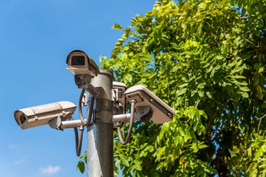 Çok açılı Cctv kamera sistemi yeşil park arka planda şehir güvenlik izlerken işletim. Gözetim ve izleme kavramı