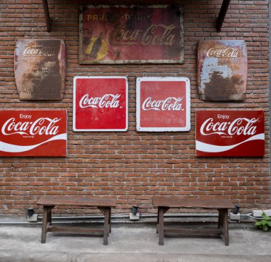 Bangkok, Tayland - 19 Haziran 2019 : Ahşap sandalyeler ile tuğla duvarda Vintage Coca Cola işareti