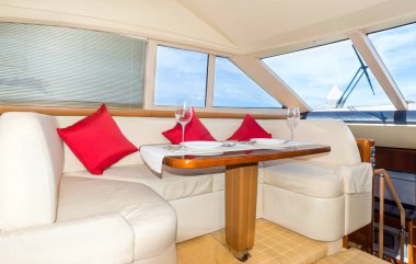 Tatil eğlence turizm seyahat ve tatil konsepti için bir yat iç rahat tasarım lüks öğle yemeği masa ayarı