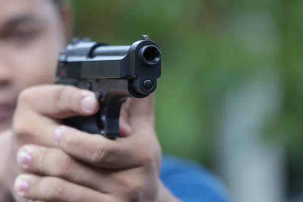 Man holding gun aiming pistol in hand ready to shoot. The Criminal robber or gangster, thief, concept