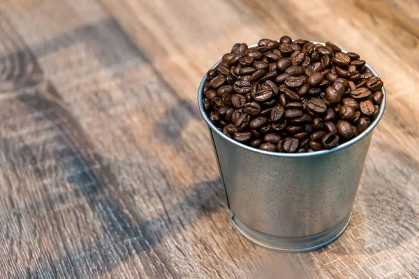 Coffee beans in metal cans on wooden table