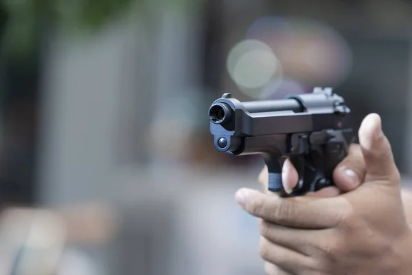 Homem segurando arma apontando pistola na mão pronto para atirar — Fotografia de Stock