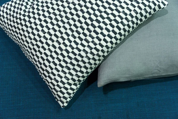 Modern fabric pillow checkered pattern on blue fabric sofa interior