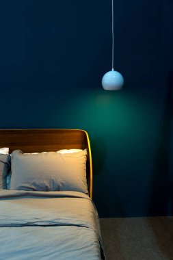 Yeşil duvar iç dekorasyonu ile lüks yatak ve tavan lambası modern kumaş yastık