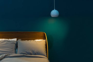 Yeşil duvar iç dekorasyonu ile lüks yatak ve tavan lambası modern kumaş yastık