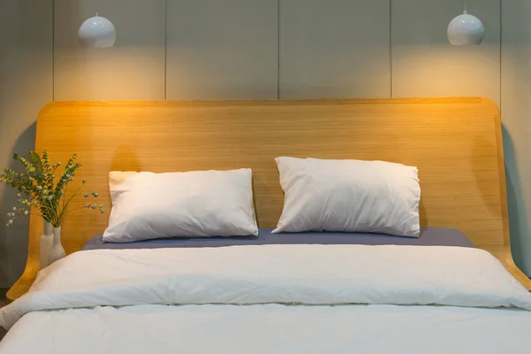 豪華なベッドと天井ランプのインテリアにモダンなファブリック枕 — ストック写真