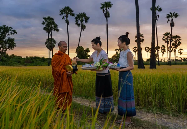 女性はタイの仏教の信念に従って農村部で僧侶とメリットを作る — ストック写真