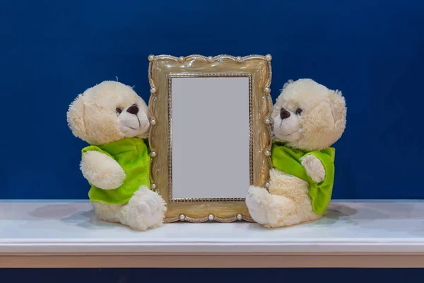 Classic picture frame with little bears doll on the marble table and blue wall decoration