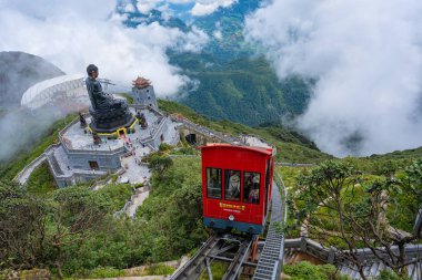 SA PA, VIETNAM - Aug 12, 2019 :  Buddha statue with tram at summit of Fansipan mountain peak the highest Indochina located travel destination in Sapa Hoang Lien Son mountain range, Lao Cai,  Vietnam clipart
