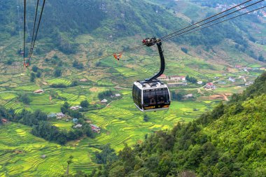 SA PA, VIETNAM - 12 Ağustos 2019: Dünyanın en uzun elektrikli teleferiği Fan Si Pan veya Pang Xi Pang dağlarının zirvesine gidiyor SA PA, Lao Cai, Vietnam 'daki güzel pirinç tarlası ile Hindiçin' in en yüksek dağı