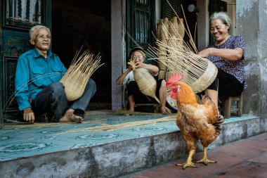 Hung Yen, Vietnam - 10 Ağustos 2019 : Thu Sy ticaret köyünde eski geleneksel evde bambu balık kapanı veya örgü yapan eski Vietnamlı kadın zanaatkar grubu, Hung Yen şehri Hanoi, Vietnam