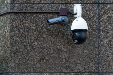 Mermer duvardaki modern CCTV kamerası izleme ve izleme konsepti suçluyu koruyor.