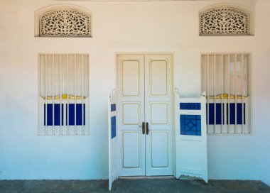 Beyaz beton duvarda eski beyaz ahşap kapı koloni tarzı mimari bina