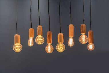 Modern grup tungsten tavan lambaları. Lamba kapağı ahşaptan yapılmıştır. Gri arka plan konseptinde güzel bir dokusu vardır.
