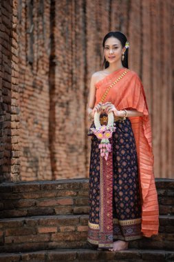 Tayland 'da Ayutthaya, Tayland' daki antik tapınakta Tayland kültürüne göre ellerinde güzel çelenklerle ve geleneksel Tayland elbisesi giymiş güzel Asyalı kadınlar.