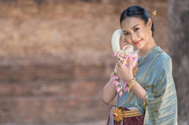 Tayland 'da Ayutthaya, Tayland' daki antik tapınakta Tayland kültürüne göre ellerinde güzel çelenklerle ve geleneksel Tayland elbisesi giymiş güzel Asyalı kadınlar.