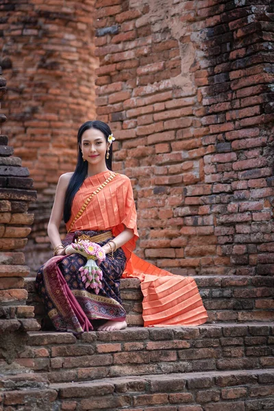 美しいガーランドを手にし タイの古代寺院でタイ文化に応じて伝統的なタイのドレスの衣装を身に着けている美しいアジアの女性 Ayutthaya Thailand — ストック写真