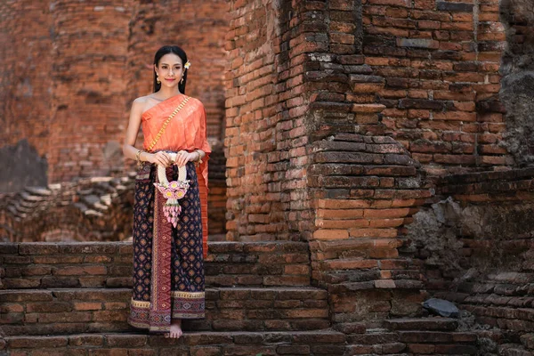美しいガーランドを手にし タイの古代寺院でタイ文化に応じて伝統的なタイのドレスの衣装を身に着けている美しいアジアの女性 Ayutthaya Thailand — ストック写真