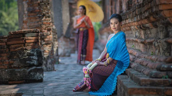 Beautiful Asian Thai women wearing in Thai dress costume traditional according Thai culture and tradition at the ancient temple Ayutthaya, Thailand