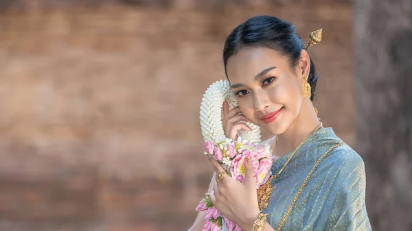 美しいガーランドを手に タイの古代寺院でタイの文化に応じて伝統的なタイのドレスの衣装を身に着けている美しいアジアのタイ人女性 Ayutthaya Thailand — ストック写真